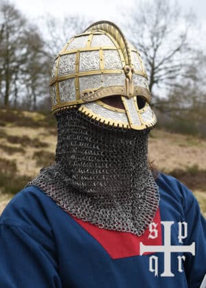 Casque viking de type Valsgärde, issu des riches sépultures suédoises datant du VIIe au IXe siècle, incarne l'ingéniosité et le raffinement des artisans scandinaves. Orné de plaques en métal rivetées sur une structure en cuir, ce casque à crête distinctive offre une protection efficace tout en arborant des motifs gravés ou en relief, souvent inspirés de la mythologie nordique. Ses détails élaborés reflètent le statut élevé de son porteur, soulignant à la fois sa puissance martiale et son rôle dans la société guerrière viking